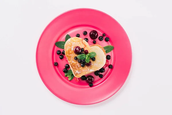 Draufsicht auf herzförmigen Pfannkuchen mit Beeren und Minze isoliert auf weißem, Valentinstag-Konzept — Stockfoto