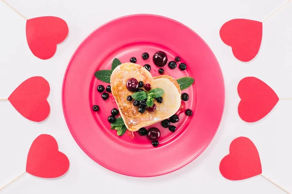 Draufsicht auf herzförmigen Pfannkuchen mit Beeren isoliert auf weißem, Valentinstag-Konzept — Stockfoto