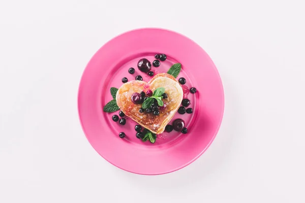 Draufsicht auf herzförmigen Pfannkuchen mit Beeren und Minze isoliert auf weißem, Valentinstag-Konzept — Stockfoto