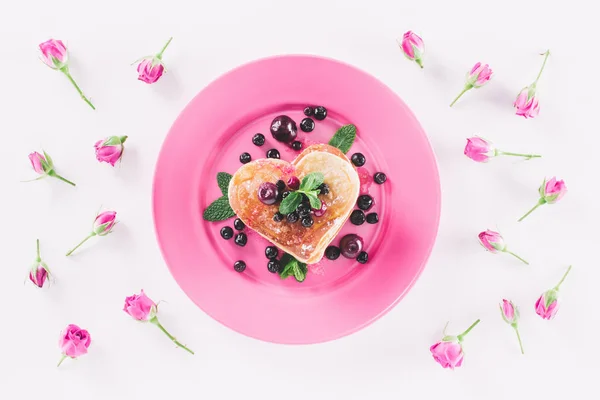 Draufsicht auf herzförmigen Pfannkuchen und rosa Rosen isoliert auf weißem, Valentinstag-Konzept — Stockfoto