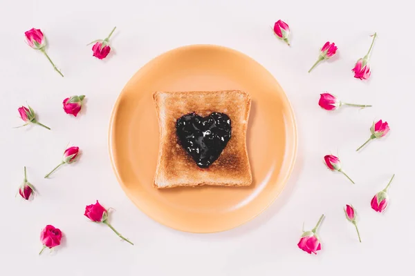 Vista dall'alto del pane tostato con marmellata su piatto giallo isolato su bianco — Foto stock