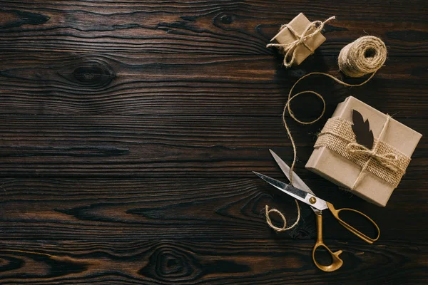 Tendido plano con regalos envueltos, cuerda y tijeras en la superficie de madera — Stock Photo