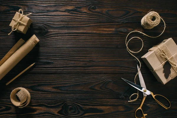 Flat lay with wrapped presents, rope and scissors on wooden surface — Stock Photo