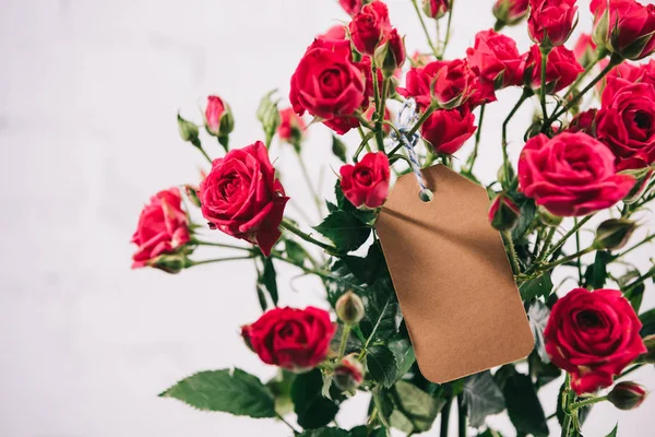 Vista de cerca de hermoso ramo de rosas con tarjeta en blanco - foto de stock