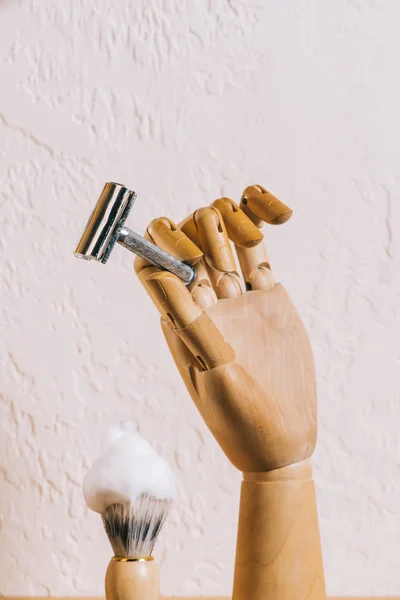 Close up view of brush with shaving foam and blade in wooden hand — Stock Photo