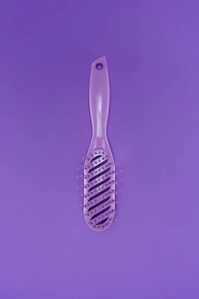 Vista de cerca del cepillo de pelo púrpura aislado en púrpura - foto de stock