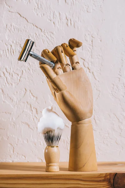 Close up view of brush with shaving foam and blade in wooden hand — Stock Photo