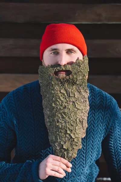 Portrait of man with beard made of wood bark looking at camera outdoors — Stock Photo