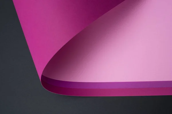 Rollo de papel púrpura y rosa aislado en negro - foto de stock