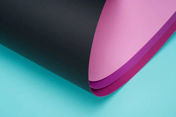 Rouleau de papier noir et rose sur turquoise — Photo de stock