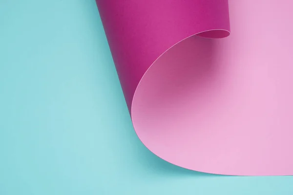 Twisted pastel pink paper on turquoise — Stock Photo