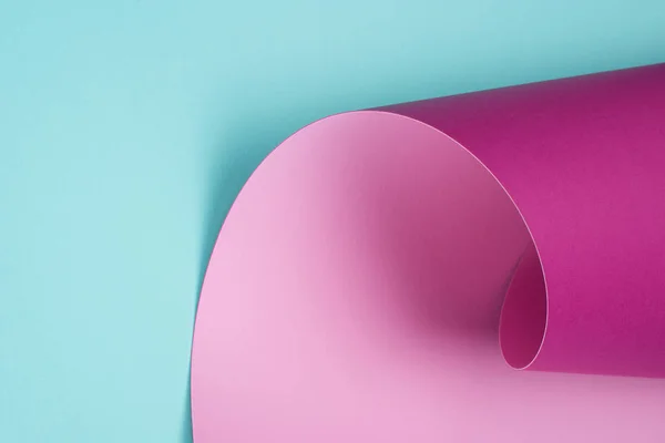Крученая пастельно-розовая бумага на бирюзе — стоковое фото