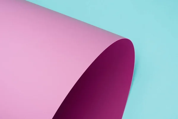 Twisted pink paper isolated on turquoise — Stock Photo