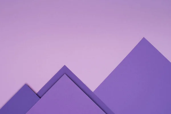 Montañas de papel púrpura sobre fondo violeta claro - foto de stock