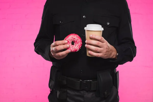 Cropped shot of policeman holding doughnut and paper cup of coffee — Stock Photo