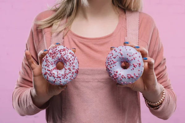 Cropped shot of woman covering breast with glazed doughnuts — Stock Photo