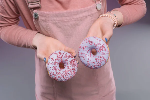 Обрізаний знімок жінки, що тримає глазуровані смачні пончики в руці — стокове фото