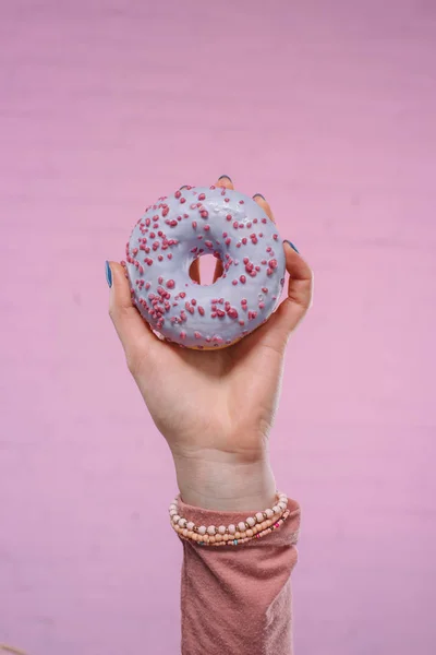 Обрізаний знімок жінки, що тримає смачний глазурований пончик в руці — стокове фото