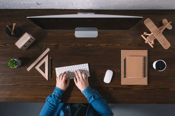 Abgeschnittene Aufnahme einer Person, die auf der Tastatur tippt und den Desktop-Computer am Arbeitsplatz benutzt — Stockfoto