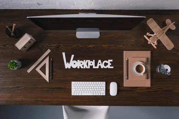 Vista superior do local de trabalho da palavra com computador desktop e material de escritório na mesa de madeira — Fotografia de Stock
