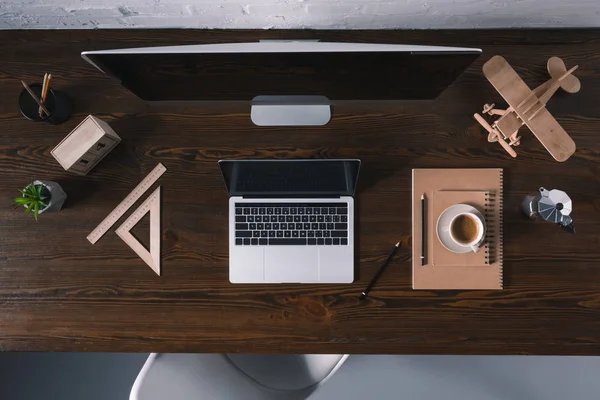 Верхний вид настольного компьютера, ноутбука и офисных принадлежностей на деревянном столе — стоковое фото