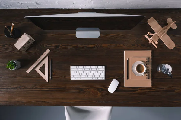 Vista superior de la computadora de escritorio y suministros de oficina en la mesa de madera - foto de stock