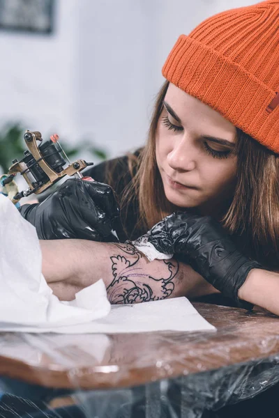 Menino e mestre de tatuagem feminino durante o processo de tatuagem em estúdio — Fotografia de Stock