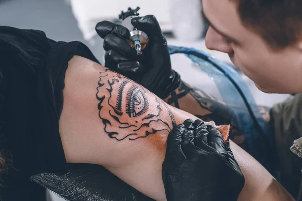 Tatuagem artista em luvas trabalhando em estúdio — Fotografia de Stock