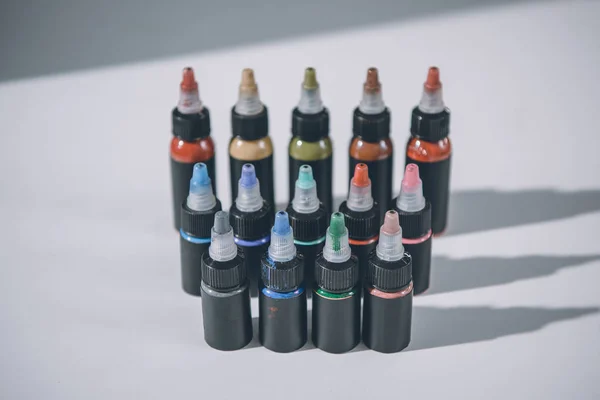 Bottles with colorful tattoo ink in rows — Stock Photo
