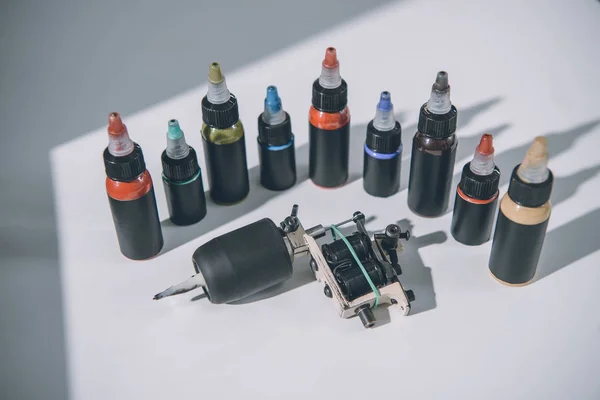 Bottiglie con inchiostro colorato tatuaggio e macchina — Foto stock