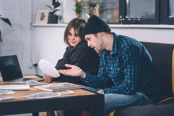 Girl and guy discussing tattoo design in studio — Stock Photo