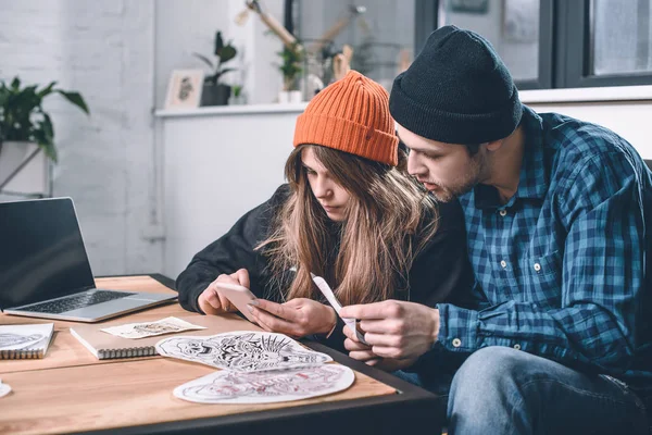 Homme et femme choisissant la conception de tatouage en studio — Photo de stock