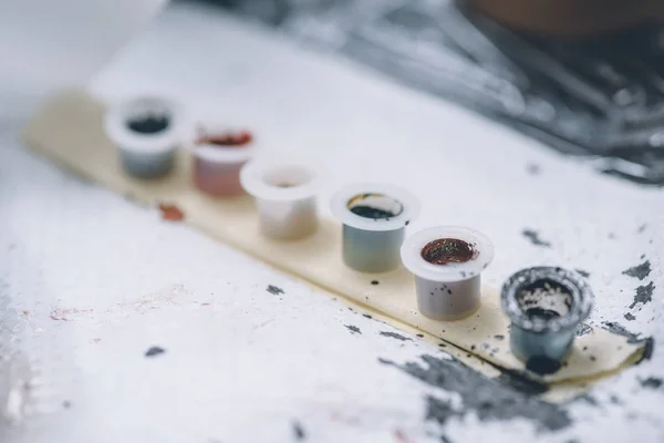 Latas de tinta de tatuagem em linha na mesa — Fotografia de Stock