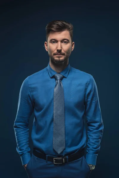 Уверенный в себе человек в голубой рубашке изолирован на синий — стоковое фото