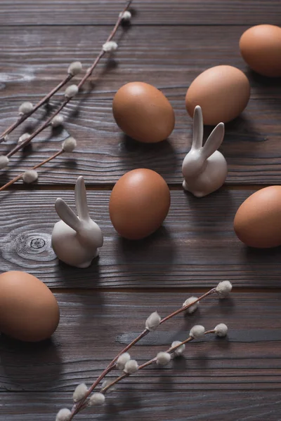 Uova di pollo e conigli pasquali sulla superficie di legno — Foto stock