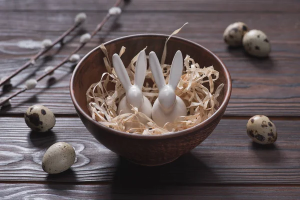 Lapins de Pâques dans un bol avec de la paille sur la table — Photo de stock