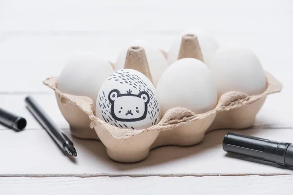 Painted bear on easter egg with marker on table — Stock Photo