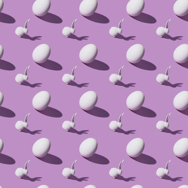 Set of chicken eggs and easter rabbits on purple background — Stock Photo