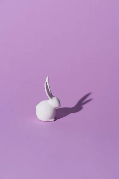 Un lapin de Pâques sur la surface violette — Photo de stock