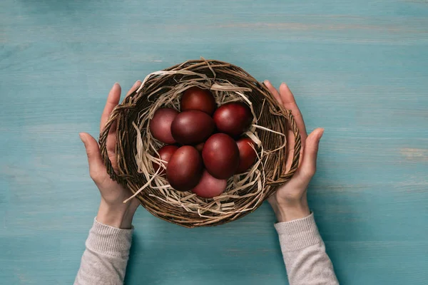 Imagem cortada de mulher segurando cesta de Páscoa com ovos pintados — Fotografia de Stock