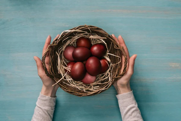 Abgeschnittenes Bild einer Frau, die einen Osterkorb mit bemalten Eiern hält — Stockfoto