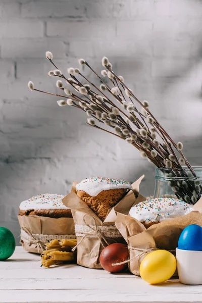 Osterbrot, bemalte Eier, Kätzchen und Kerzen auf Holztisch — Stockfoto