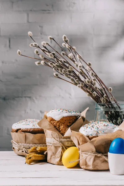 Osterbrot, bemalte Hühnereier und Kerzen auf Holztisch — Stockfoto