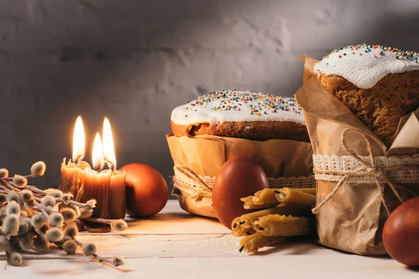 Великодній хліб, розфарбовані яйця та свічки на столі — стокове фото