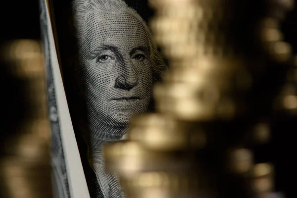 Selective focus of dollar banknote and pile of coins isolated on black — Stock Photo