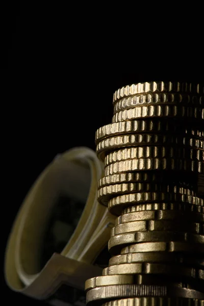 Selective focus of stack of coins and rolled banknotes isolated on black — Stock Photo