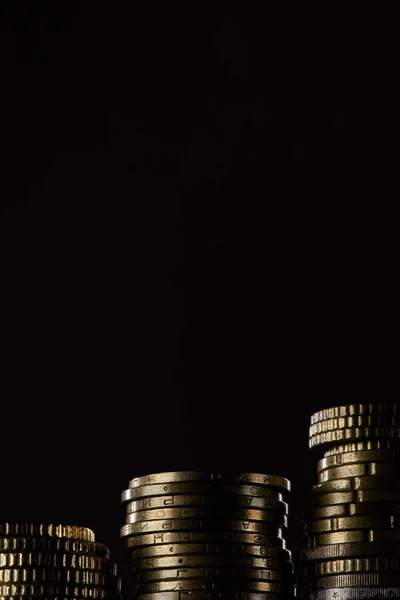 Vista da vicino di pile di monete isolate su nero — Foto stock