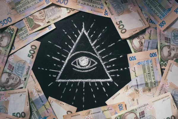 Плоский лежав з організував 500 гривень банкнот, що знаходяться навколо очей Провидіння звернено на дошці — стокове фото