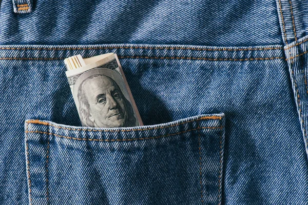 Close up view of roll of dollar banknotes in jeans pocket — Stock Photo