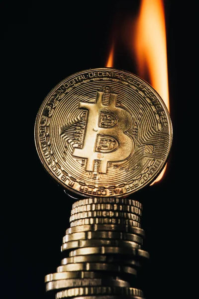 Close up view of pile of golden bitcoins with fire isolated on black — Stock Photo